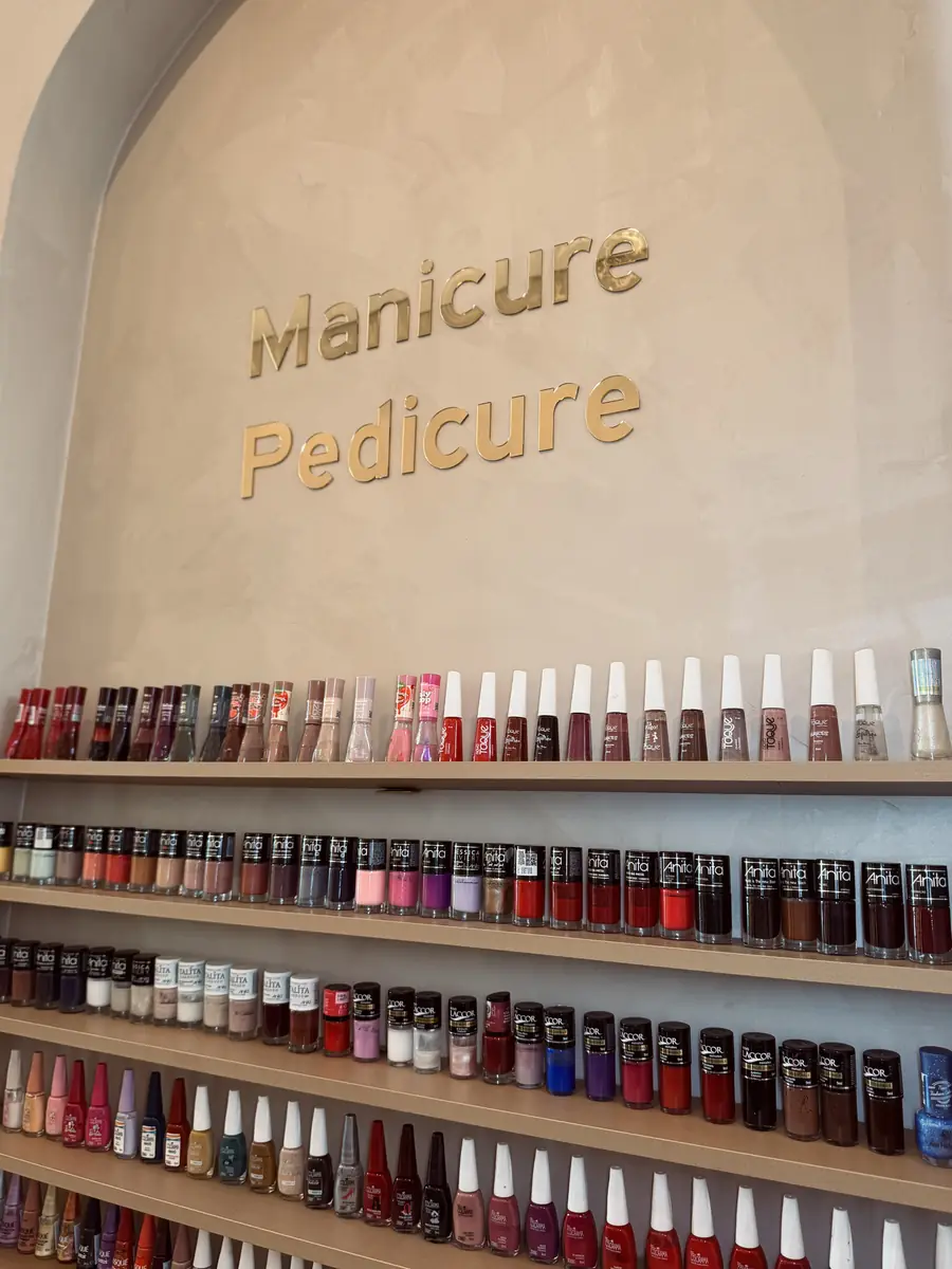Parede de esmaltes na área de manicure e pedicure da Allume