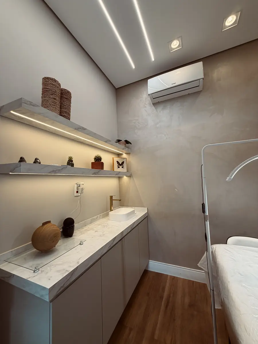 Sala de estética com bancada em mármore e prateleiras